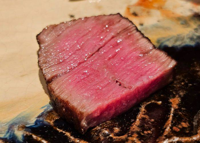 An especially juicy cut of wagyu beef, shining in the light of the restaurant.